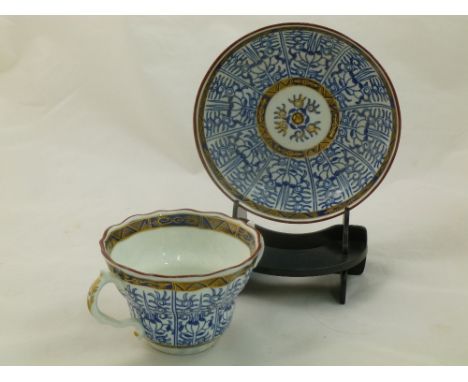 A Worcester porcelain two-handled chocolate cup and saucer, decorated in under glazed blue with red enamelled rims and gilt d