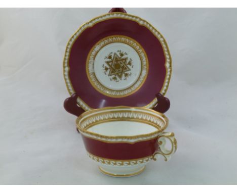 An H & R Daniel porcelain breakfast cup and saucer, First Gadroon shape, decorated with maroon bands and gilt star motif, eac