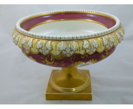 An H & R Daniel porcelain centre piece, Shell Border shape, with beaded and acanthus leaf rim, maroon ground, raised on a squ