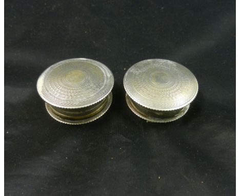 A pair of circular silver lidded powder and rouge pots, Birmingham 1929, with engine turned decoratioin, 43mm diameter, 1.63o