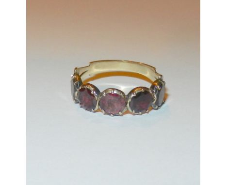 A Georgian gold and garnet five stone ring, the round shallow mixed-cut stones in closed foil back pinched rub-over settings,