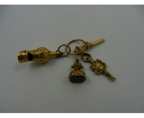 A miniature Victorian gold whistle, 35mm long, a gold watch key, 29mm long, suspended from a gold split ring (at fault), comb