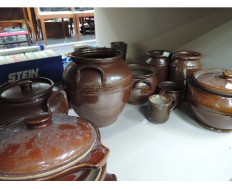 A shelf of various salt glazed pots and jars etc.