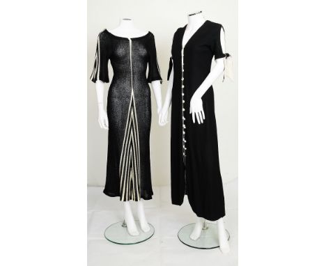 A 1970s black dress with black and white tie detailing to sleeves, white buttons along front; together with a 1970s black kni