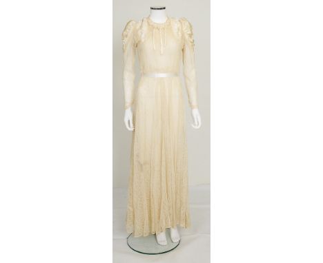 An early 20th Century cream lace wedding dress with satin rolls detailing to neckline, satin detailing on shoulders, tie wais