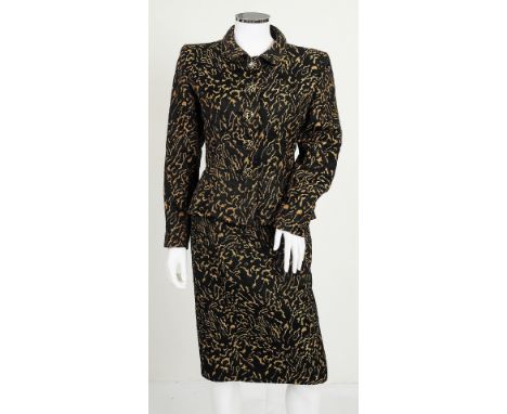 A 1960s black and gold two piece Yves Saint Laurent skirt suit, gold swirl design, jacket with chunky black and gold coloured