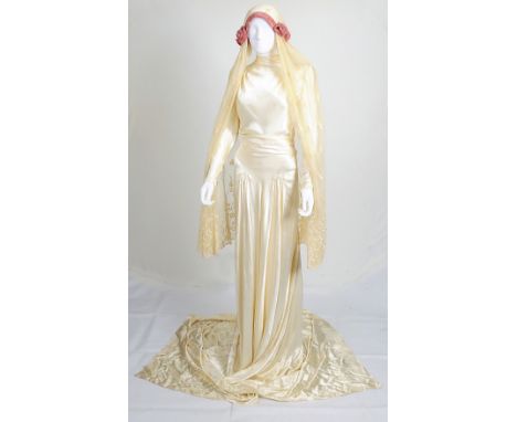 A 1920s style cream satin wedding dress, high neck, long sleeves with ruched detailing to shoulders, waist and front, matchin