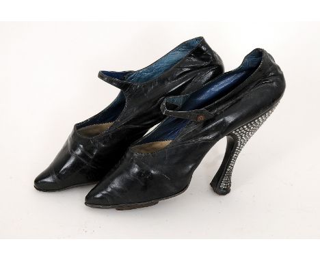 An early 20th Century pair of black high heeled shoes, heels elaborately decorated with diamantes, single button crossover st