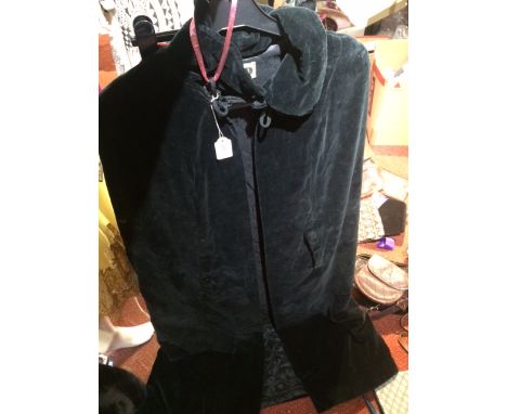 A 1960s long black velvet cape, quilted lining, tie fastening to neck; toegther with a child's red velvet French jacket with 