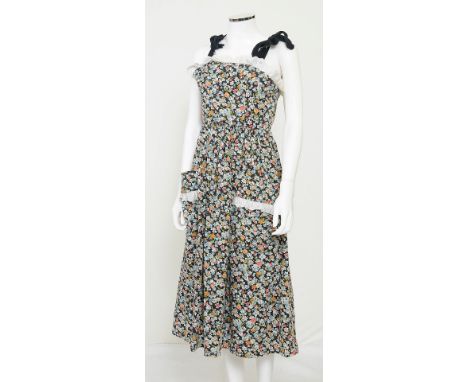 A 1970s Gina Fratini floral patterned dress, lace detailing to bust and on edge of large pockets to skirt, black bow tie stra