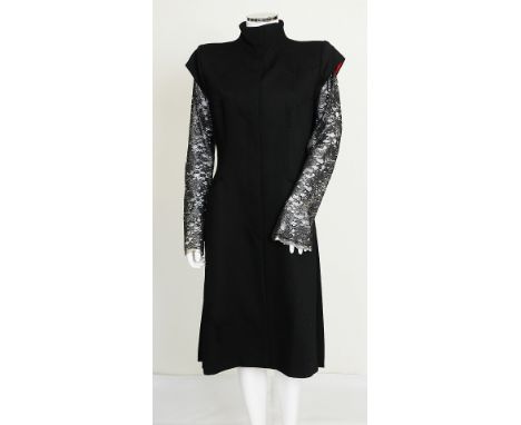 A 1997 Alexander McQueen black wool coat with silver and black lace sleeves, funnel neck, button fastening to front, pockets 