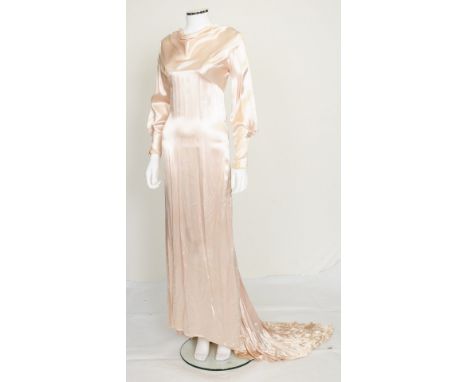 A 1930s pale pink satin wedding dress, long sleeves with ruche detailing, slightly draping detail to high neck, train to skir