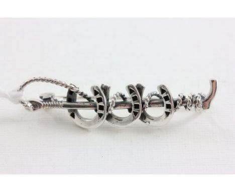 Silver Brooch in the form of Three Horse Shoes and a Whip