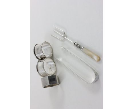 Three Silver Napkin Rings, Pair of Sugar Tongs with brightcut engraving and a Silver Three Prong Fork with Mother of Pearl Ha