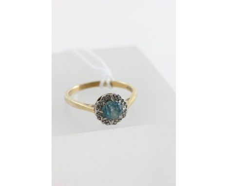 18ct Gold Ring set with a light emerald and surrounded by diamonds