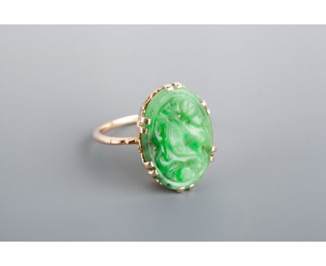 A JADE SET DRESS RING, carved oval panel set with claws in a pierced gallery, unmarked gold, finger size 'N'