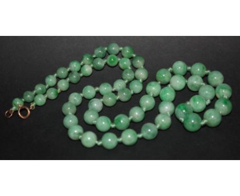 A JADE BEAD NECKLACE, fifty eight graduated beads measuring 9.5mm down to 6.5mm, 57cm long (22.5" long)