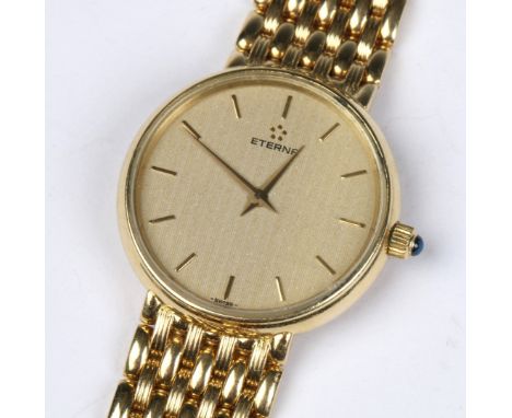 AN 18K ETERNA LADY'S WRIST WATCH, the champagne dial with baton numerals, stone inset crown and mesh strap