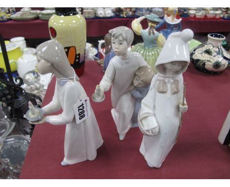 Two Lladro Pottery Figures, of a boy and girl holding a candle, a girl holding a candle and a girl holding a stick and a bask