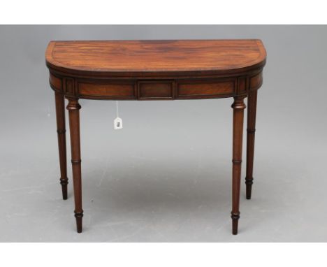 A REGENCY MAHOGANY FOLDING CARD TABLE, of rounded oblong form with ebony stringing, the banded top opening to a green baize, 