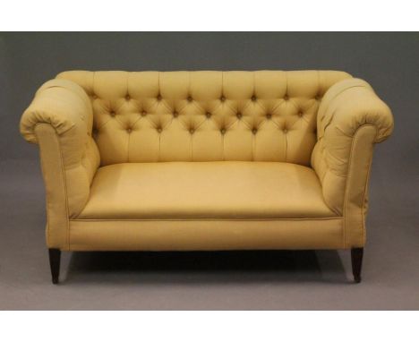 A LATE VICTORIAN MAHOGANY FRAMED DROP END SOFA of Chesterfield type, button upholstered in a gold weave, both ends hinged, ra