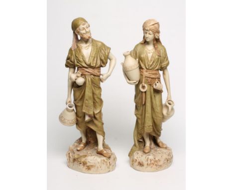 A MATCHED PAIR OF ROYAL DUX BISQUE PORCELAIN FIGURES, early 20th century, modelled as Middle Eastern water carriers standing 