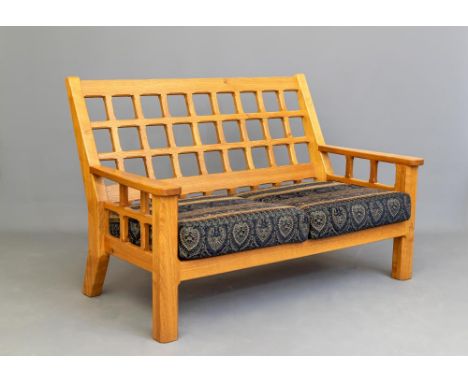 AN OAK SOFA by Horace Knight of Balk, Thirsk, North Yorkshire, of pierced trellis form with loose cushions in a blue and crea