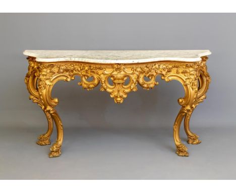 A VICTORIAN CARVED GILT WOOD AND GESSO CONSOLE TABLE, of serpentine outline with veined white marble top, the scroll edged sh