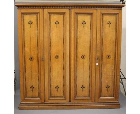 A GOTHIC REVIVAL LIGHT OAK AND BLACK STENCILLED WARDROBE, in the manner of Marsh, Jones &amp; Cribb, the moulded cornice over