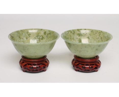 A PAIR OF TURNED AND POLISHED JADE BOWLS of plain circular form, 3 3/4" diameter, 1 1/2" high, with carved and pierced wood s