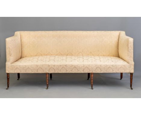 A REGENCY MAHOGANY FRAMED SOFA upholstered in champagne silk brocade, straight top rail, mildly sloping arms, raised on four 