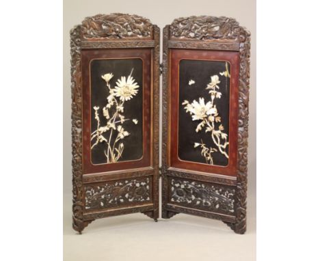 A CHINESE PADOUK WOOD AND IVORY FOLDING ROOM SCREEN, c.1900, comprising a pair of arched panels carved with dragons amongst c