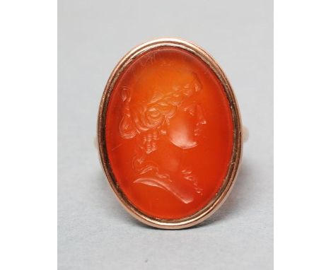 A GENTLEMAN'S SIGNET RING set with an oval cornelian seal intaglio carved with the bust portrait of a young lady with ringlet