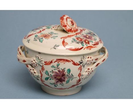 A CREAMWARE SUCRIER AND COVER, c.1775, the reeded double loop handles with flowerhead terminals, painted in colours within sc