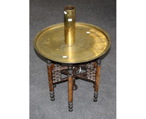 An ealy 20th century Middle Eastern brass tray top table with bobbin turned folding base, together with a WWI brass heavy gun