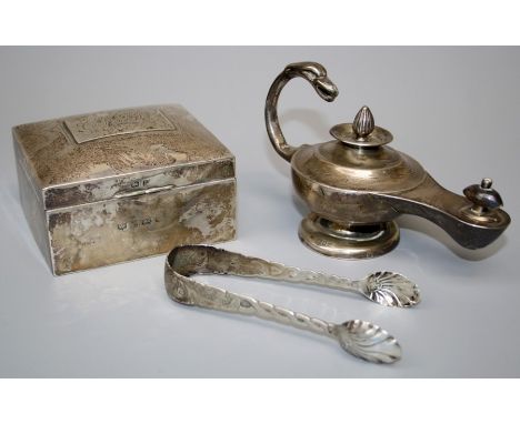 A silver lamp form table lighter, a silver cigarette box and a pair of sugar nips. Various dates and makers