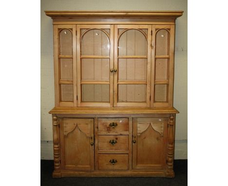 A 19th century stripped pine tall dresser, the top with arch barred glazed doors enclosing 3 shelves over 3 short drawers fla