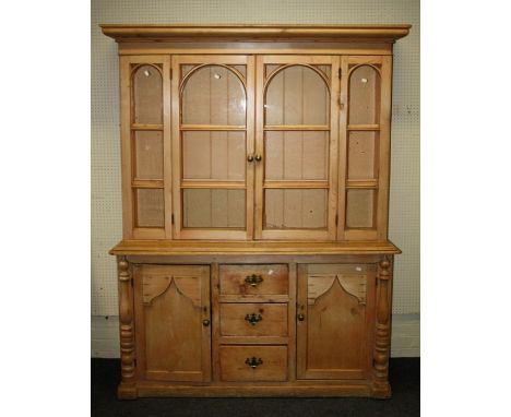 A 19th century stripped pine tall dresser, the top with arch barred glazed doors enclosing 3 shelves over 3 short drawers fla