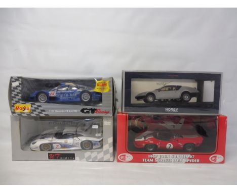 Four boxed die-cast cars 1.18 scale, to include a 1967 John Surtees and a Lola Spyder car.