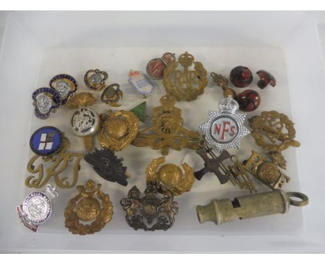 A box of brass and enamel military badges, whistle etc.