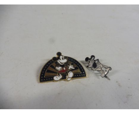 A silver and enamel Mickey Mouse badge, and one other.