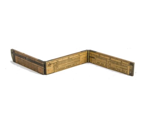 An ironmonger's three-fold rule, in boxwood, one foot, with brass joints and sliding caliper, marked with inches and hundredw