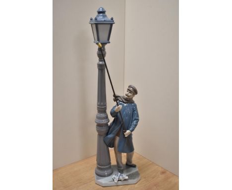 A Lladro porcelain figure 'Lamplighter' number 5205, modelled as a windswept gentleman lighting a gas street lamp, printed an