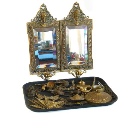 Pair of embossed brass wall mirrors (lacking sconces), brass door knocker, set of four brass clock dial corner decorations an