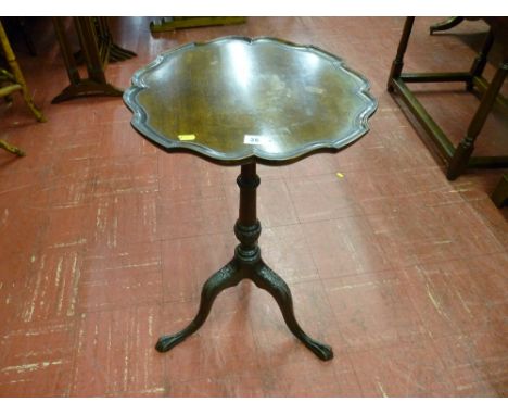 A late Victorian mahogany wine table with scalloped edge top, carved column and tripod base with slender ball and claw feet, 