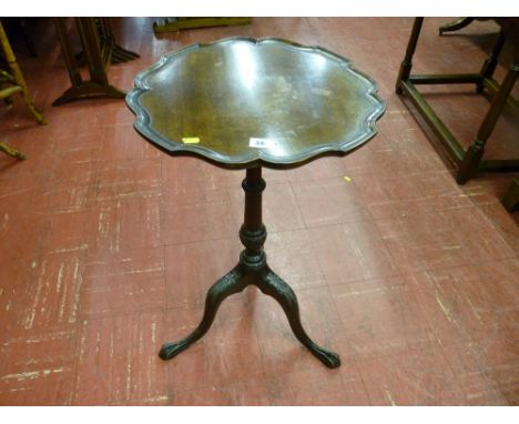 A late Victorian mahogany wine table with scalloped edge top, carved column and tripod base with slender ball and claw feet, 