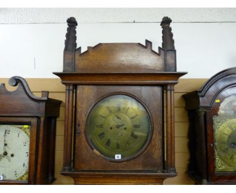 An early 19th Century Gothic style longcase clock, the 14 ins diameter circular brass dial with Roman numerals and subsidiary