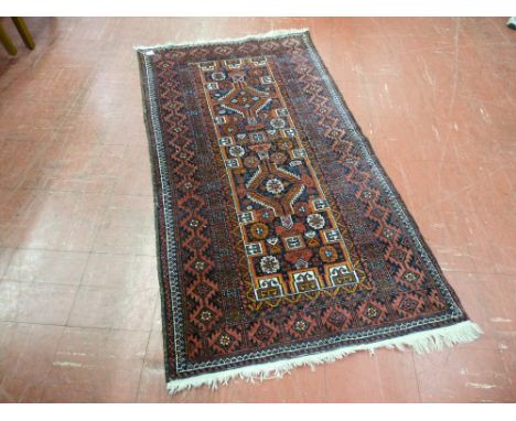 A vintage Eastern wide bordered woollen rug with tasselled ends, 164 x 87 cms, numbered cloth tag to the reverse with attache