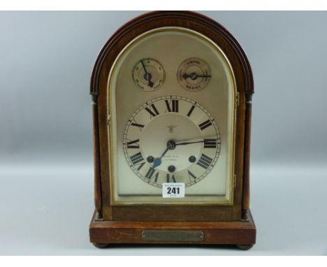 An early 20th Century mahogany dome topped mantel clock, the silvered dial set with Roman numerals, subsidiary slow, fast and