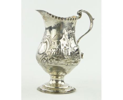 A George III silver helmet shaped cream jug,
with embossed village scene by Thomas Wallis, London 1778.